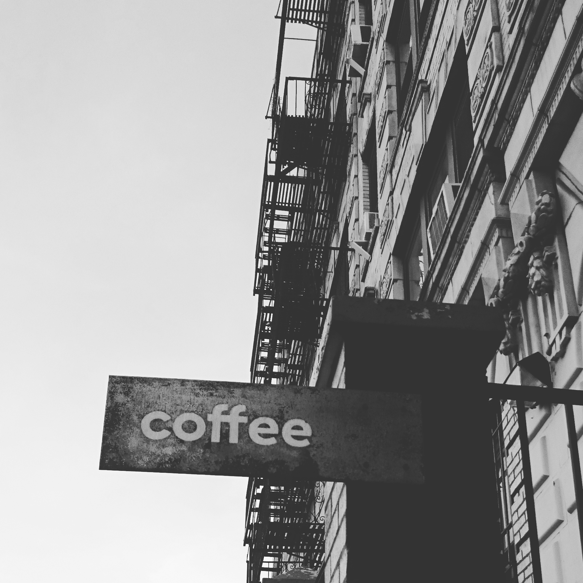 a black and white picture of a coffee shop sign