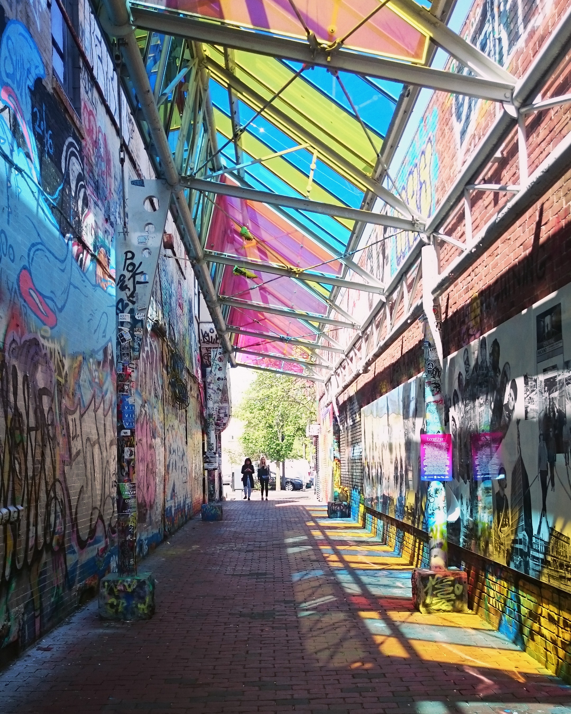 an alleyway with brightly coloured graffiti