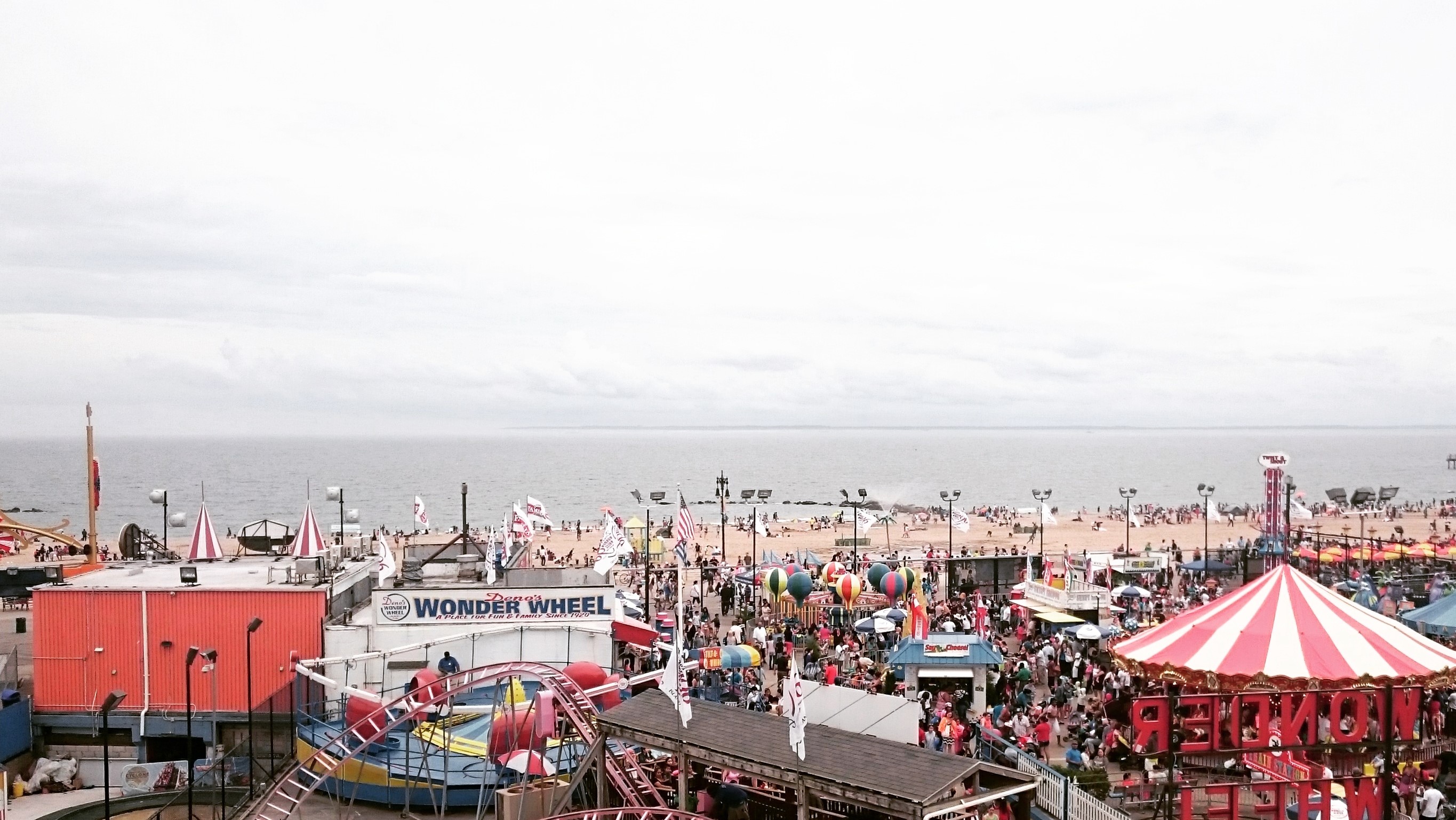 a widescreen view of a carnival next to the ocean